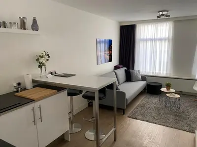 a kitchen and living room with a table and a couch at Rosies Place in Amsterdam