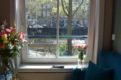 a window with a vase of flowers on a table at The LIF Boutique in Amsterdam