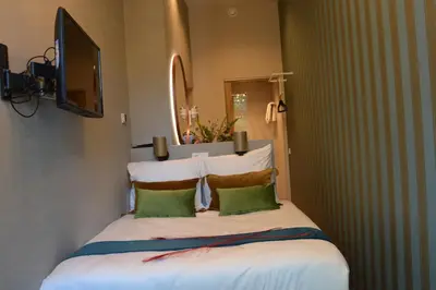 a bedroom with a bed with two pillows and a television at The LIF Boutique in Amsterdam