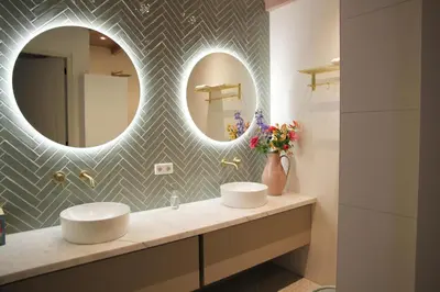 a bathroom with two sinks and a mirror at De Bosuil in Bergen