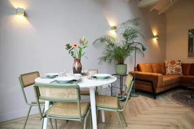a dining room with a white table and chairs at De Bosuil in Bergen