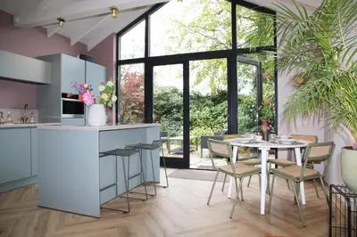 a kitchen and dining room with a table and chairs at De Bosuil in Bergen