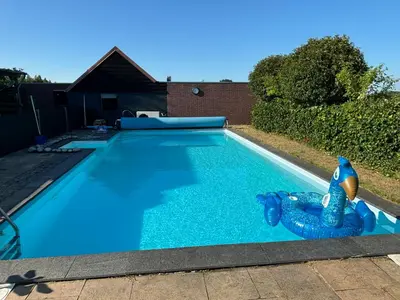 a swimming pool with a blue inflatablelatable at DE WEELEN met Jacuzzi en of Zwembad Topkeuze Romantiek in Lutjebroek