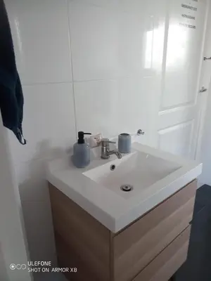 a bathroom with a white sink and a mirror at DE WEELEN met Jacuzzi en of Zwembad Topkeuze Romantiek in Lutjebroek