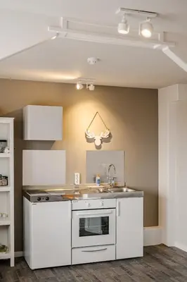 a kitchen with white cabinets and a sink at Short Stay Zandvoort in Zandvoort