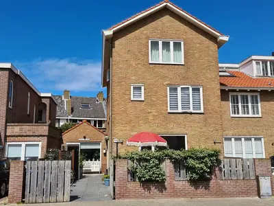 a brick house with a red umbrella in front of it at Short Stay Zandvoort in Zandvoort