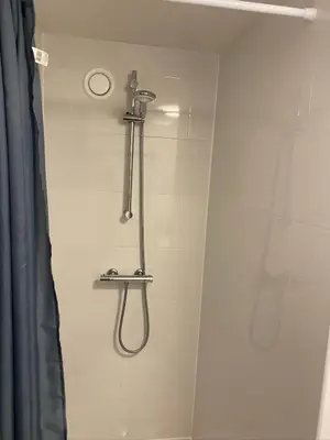 a shower in a bathroom with a shower head at Friend zone in Zaandam