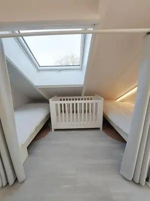 a attic room with two beds and a window at Luxe vrijstaand gastenverblijf - landelijk gelegen in IJsselstein