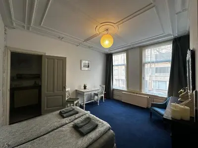 a bedroom with a bed and a desk in it at De Stijlkamer in Amsterdam
