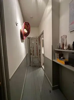 a hallway with a door and a basket on the wall at De Stijlkamer in Amsterdam