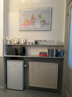a kitchen with a radiator and a shelf with books at De Stijlkamer in Amsterdam