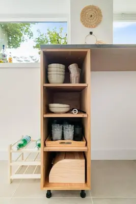 a wooden cabinet with plates and bowls in a kitchen at Chique Ibiza Zaandam in Zaandam