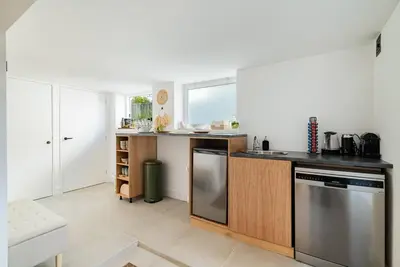 a kitchen with a counter with a sink and a dishwasher at Chique Ibiza Zaandam in Zaandam