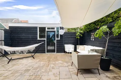 a patio with a hammock and a black wall at Chique Ibiza Zaandam in Zaandam