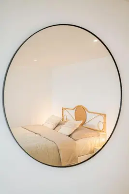 a mirror reflecting a bed with two pillows at Chique Ibiza Zaandam in Zaandam