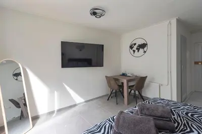 a bedroom with a bed and a table and a tv at Zaras Studio Hermes in Zandvoort