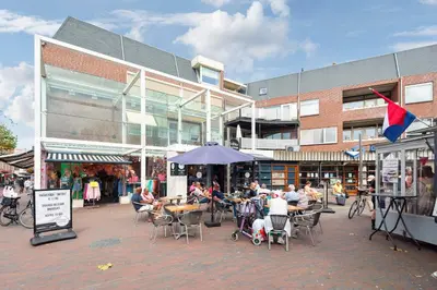 a group of people sitting at tables in front of a building at Zaras Studio Hermes in Zandvoort