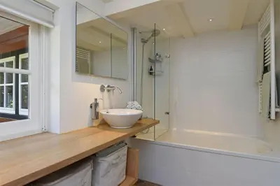 a bathroom with a sink and a shower and a tub at Natuurhuis in het Gooi in Naarden