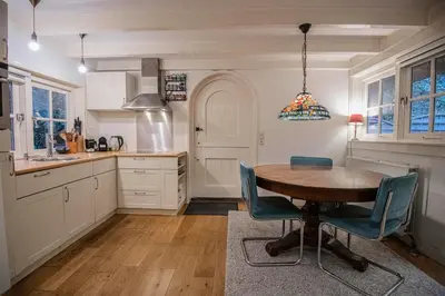 a kitchen with a wooden table and blue chairs at Natuurhuis in het Gooi in Naarden