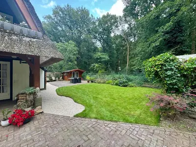 a garden with a yard of grass and flowers at Natuurhuis in het Gooi in Naarden
