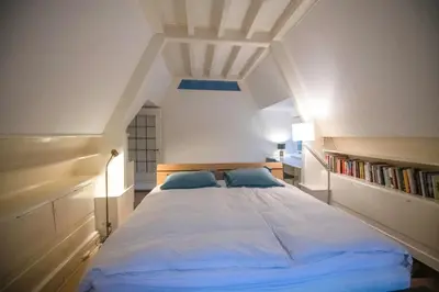 a bedroom with a large bed with blue pillows at Natuurhuis in het Gooi in Naarden