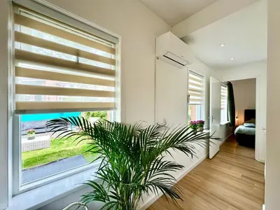 a living room with a large window and a plant at Modern Appartment Free Parking in Zandvoort