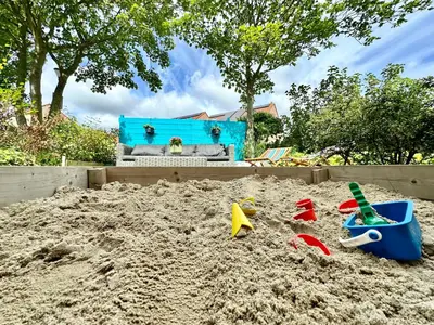 a pile of sand with toys in a sandbox at Modern Appartment Free Parking in Zandvoort