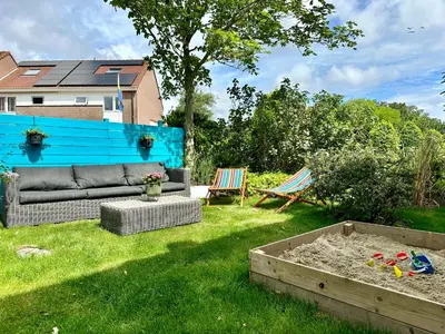 a backyard with a couch and a sandbox at Modern Appartment Free Parking in Zandvoort
