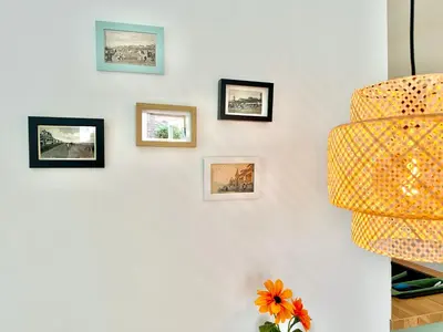 a white wall with framed pictures on it at Modern Appartment Free Parking in Zandvoort
