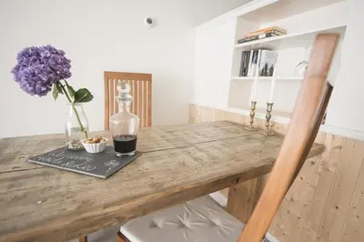 a wooden table with a bottle and a vase of flowers at B&B Louisehoeve in Linschoten