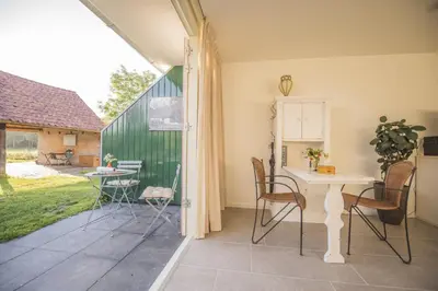 a room with a table and chairs and a patio at B&B Louisehoeve in Linschoten