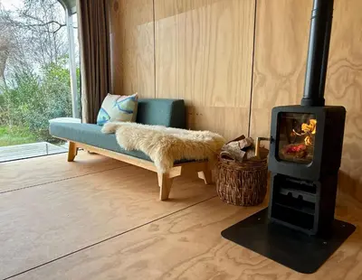 a living room with a couch and a wood stove at Huisje te huur van 15 feb tot 15 mrt voor tweeduizend euro vier weken in Zevenhuizen