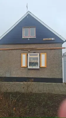 a house with a window on the side of it at De Stormmeeuw in Egmond aan Zee