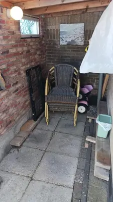 a chair sitting on a patio in a brick wall at De Stormmeeuw in Egmond aan Zee