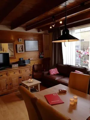 a living room with a couch and a table at De Stormmeeuw in Egmond aan Zee