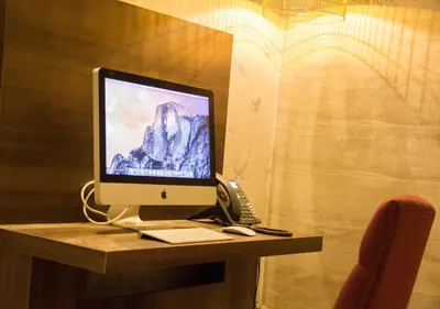 a computer monitor sitting on a desk with a phone at Hotel The Bird in Amsterdam