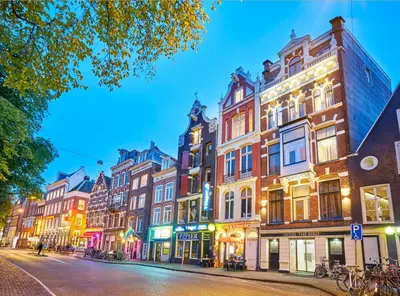 a row of buildings on a city street at night at Hotel The Bird in Amsterdam