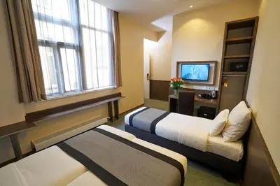 a hotel room with two beds and a television at Hotel The Bird in Amsterdam