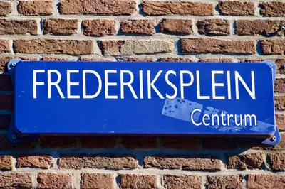 a blue street sign on a brick wall at Banzai City Amsterdam in Amsterdam