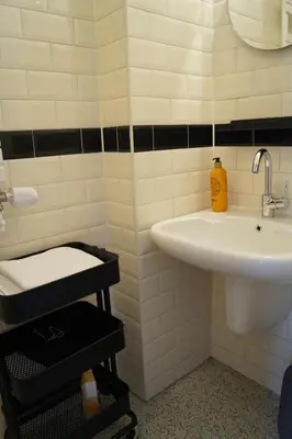 a white bathroom with a sink and a mirror at Banzai City Amsterdam in Amsterdam
