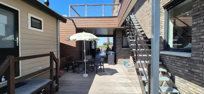 a patio with a table and an umbrella at Vinkestek Verhuur in Vinkeveen