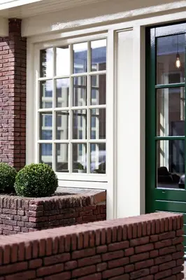 a house with a green door and a brick wall at College Hotel Alkmaar in Alkmaar