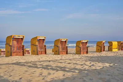 a row of beach chairs sitting on the beach at Apartments Four Seasons Voorstraat in Egmond aan Zee
