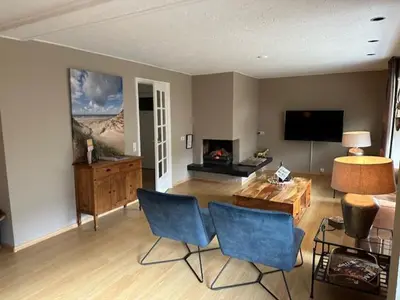 a living room with two blue chairs and a table at Apartments Four Seasons Voorstraat in Egmond aan Zee