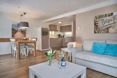 a living room with a white couch and a table at Apartments Four Seasons Voorstraat in Egmond aan Zee