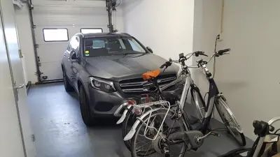 a car parked in a garage with bikes parked next to it at Apartments Four Seasons Zuiderstraat in Egmond aan Zee