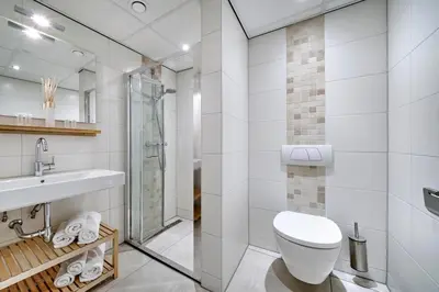 a white bathroom with a toilet and a sink at Apartments Four Seasons Zuiderstraat in Egmond aan Zee