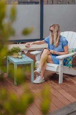 a woman sitting on a bench on a patio at Apartments Four Seasons Zuiderstraat in Egmond aan Zee