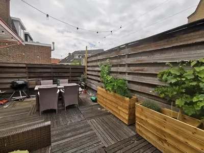 a patio with a table and chairs on a wooden deck at Centre Hilversum, 20 minutes train to Amsterdam in Hilversum
