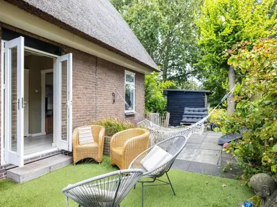 a patio with chairs and a hammock on a house at Cosy Bergen in Bergen